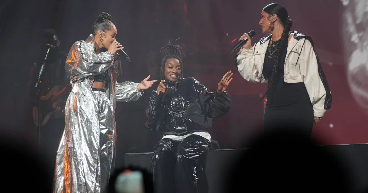 Black women singers performing wearing black white and silver puffer jackets made from moncler